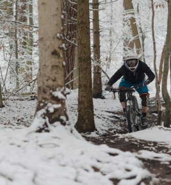 man riding bicycle on snow covered field