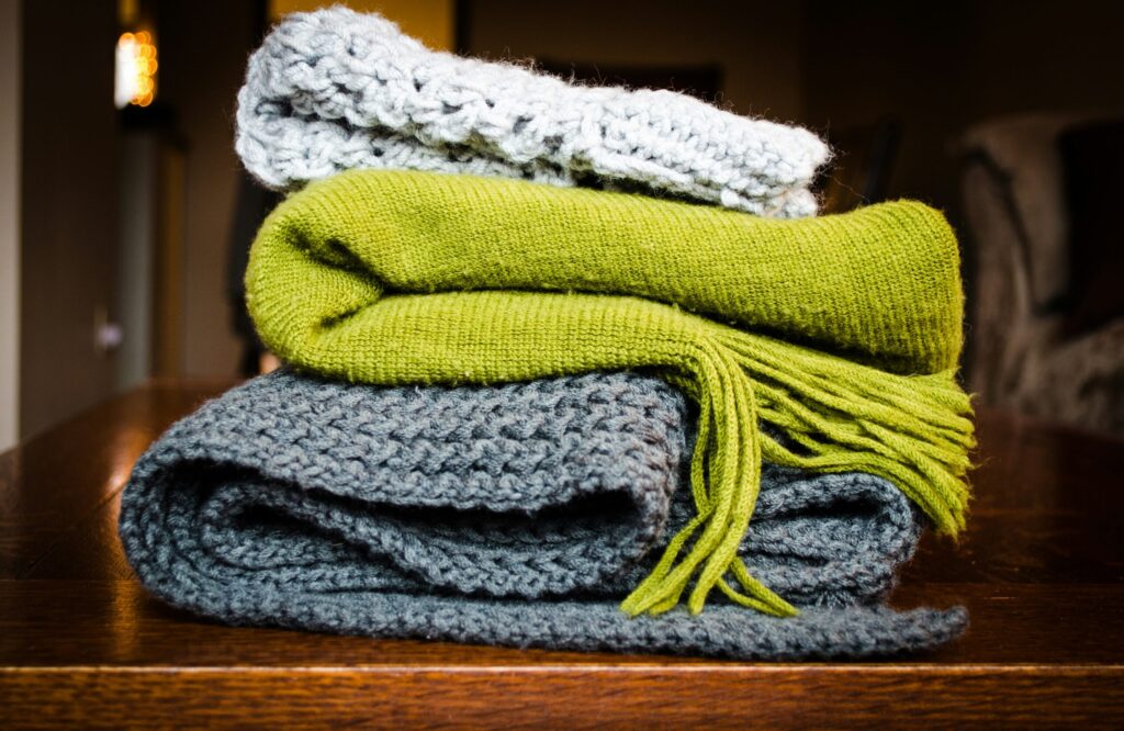 three gray, green, and white scarf on top of table