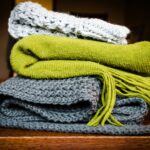 three gray, green, and white scarf on top of table
