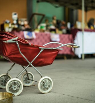 selective focus photography of red bassinet stroller