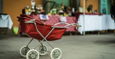 selective focus photography of red bassinet stroller