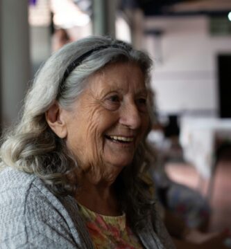 smiling woman in gray cardigan