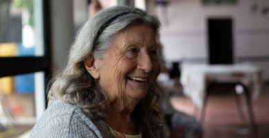 smiling woman in gray cardigan