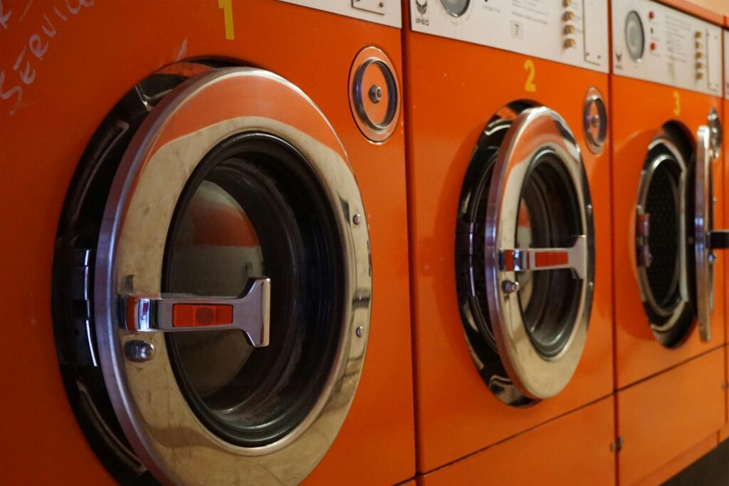 three red front-load clothes dryers