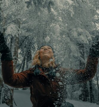 woman in black jacket blowing snow