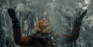 woman in black jacket blowing snow
