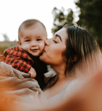 woman kiss a baby while taking picture
