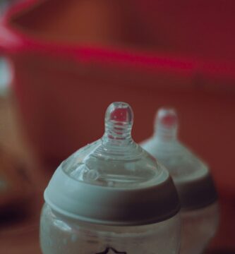 clear plastic feeding bottle on red table