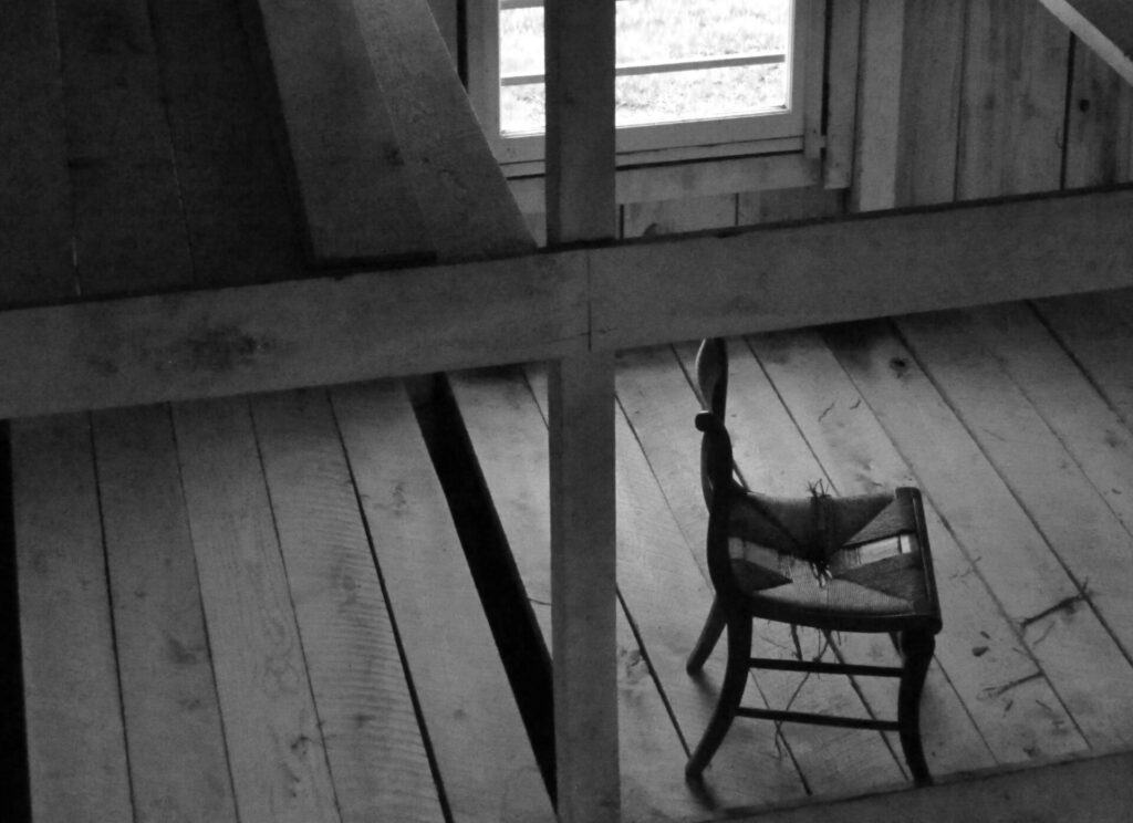 grascale photo of chair near window inside room