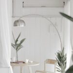 white steel chair in front round table on white rug